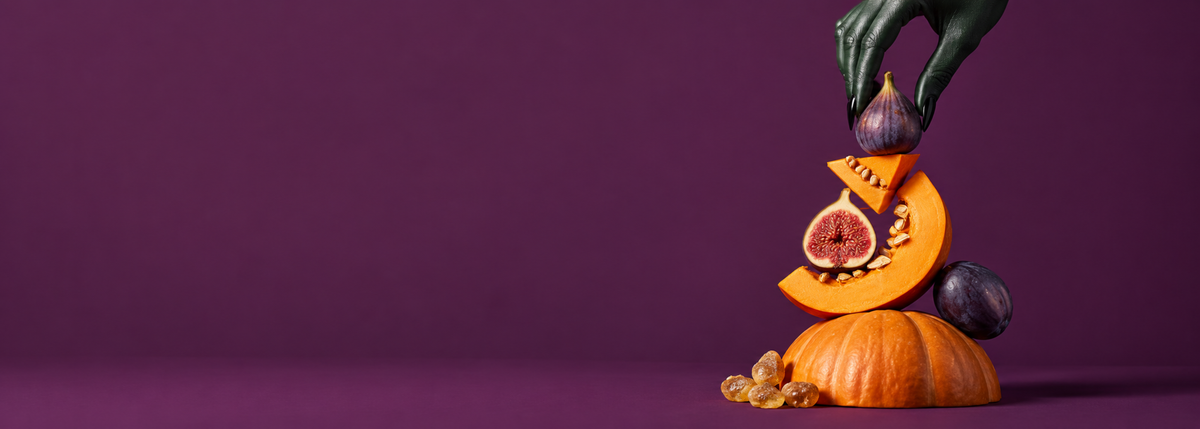 Pumpkin, figs and orange slices on a dark plum background