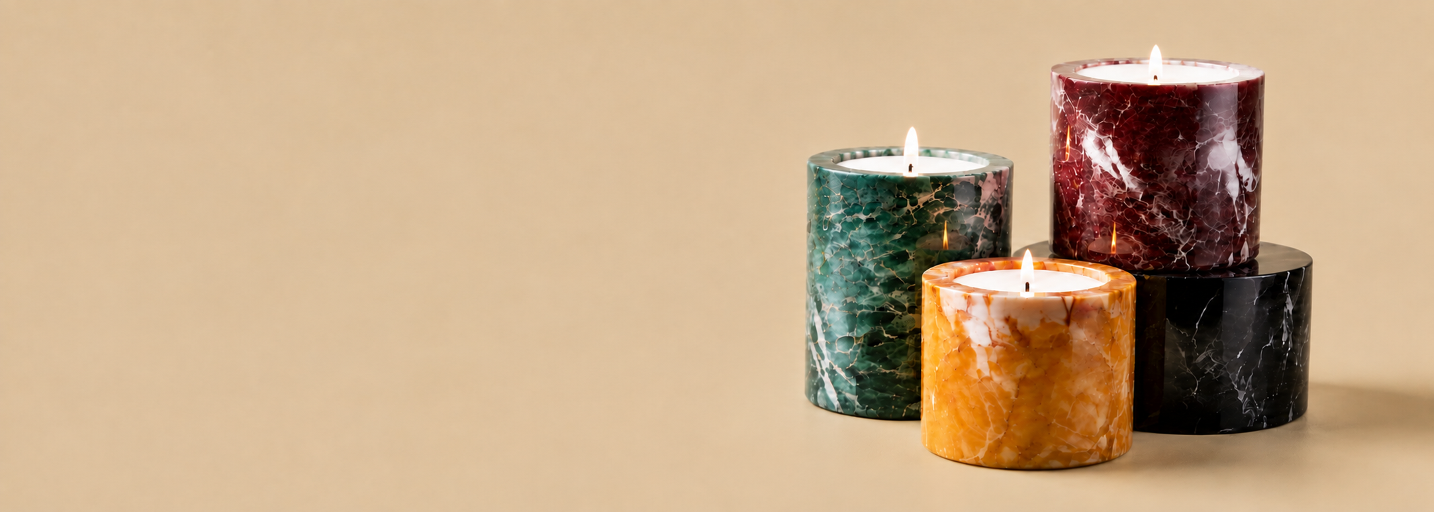 Marbled candles in teal, burgundy and amber on a warm beige background